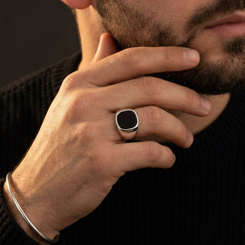 Chevalière argent 925 onyx noir portée, main contre le visage