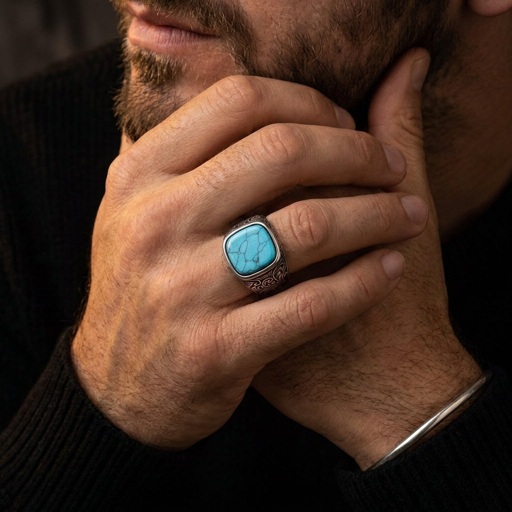 Chevalière turquoise ciselée portée, main contre le visage