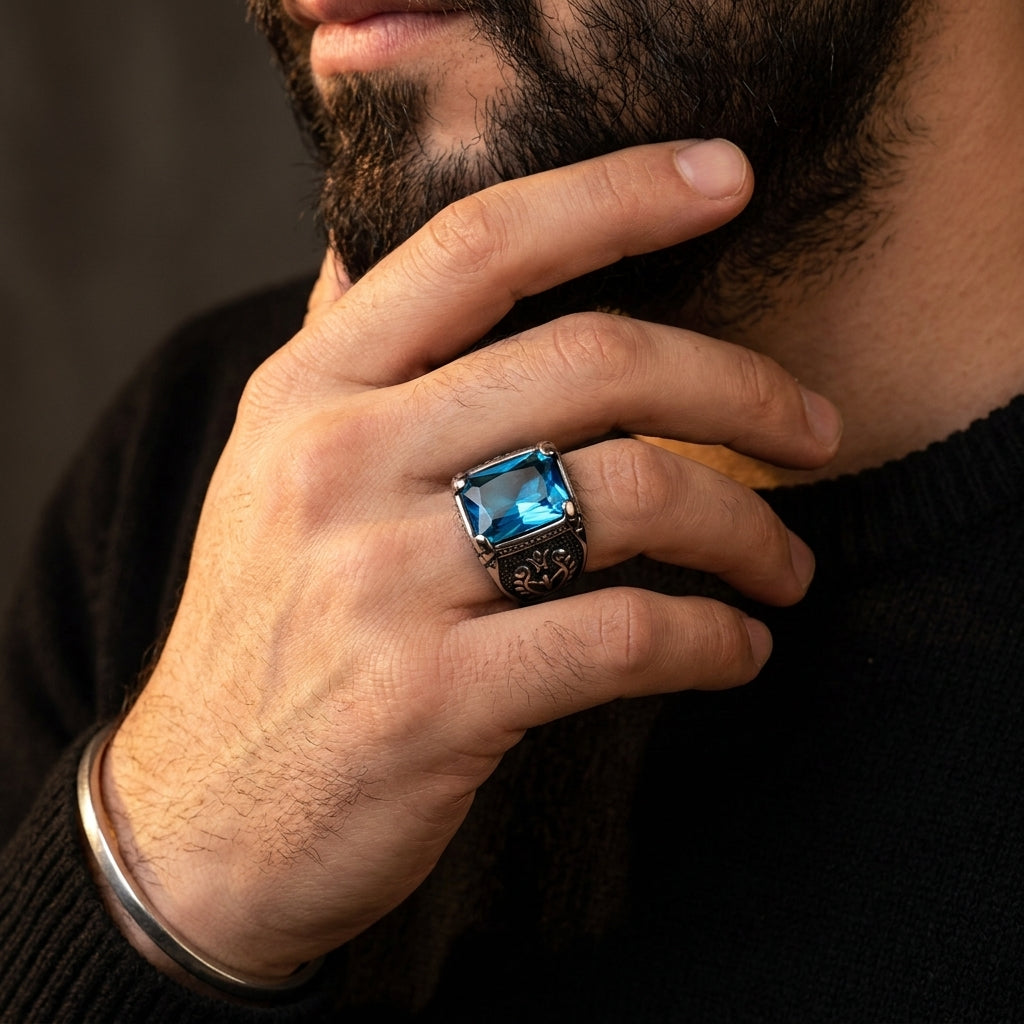 Chevalière pierre bleue gothique, portée, main contre le visage