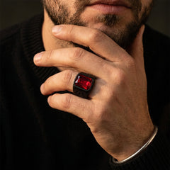 Chevalière pierre rouge noire, portée, main contre le visage